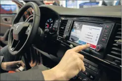  ?? Picture: AFP ?? TEST RUN: A visitor tests the app Travipay in a car at the Mobile World Congress in Barcelona this week