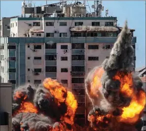  ?? (AFP) ?? A ball of fire erupts from the Jala Tower housing foreign media as it is destroyed in an Israeli airstrike in Gaza City on Saturday.