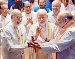  ?? — PTI ?? President-elect Ram Nath Kovind is greeted by BJP chief Amit Shah as Prime Minister Narendra Modi looks on at the NDA meeting before the Presidenti­al polls.