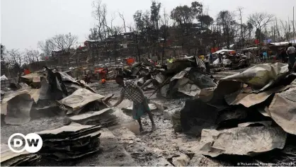  ??  ?? A Rohingya refugee stands among the remains of burnt materials after a fire broke out recently at a camp in Cox's Bazar