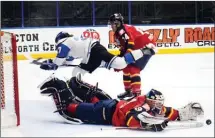  ?? DAVID CROMPTON/Penticton Herald ?? Vernon Vipers goalie Max Palaga sprawls to make a save as Penticton Vees forward Drew Elser drives to the net during BCHL action on Friday at the SOEC. Also looking on is Vernon forward Jesse Lansdell.