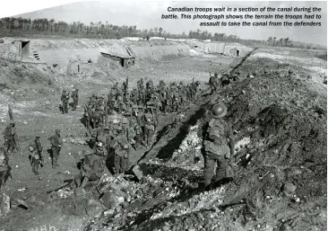  ??  ?? Canadian troops wait in a section of the canal during the battle. This photograph shows the terrain the troops had to assault to take the canal from the defenders