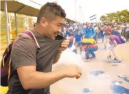  ??  ?? Un hombre se cubre del gas lanzado por federales luego que migrantes pasaron a México en el cruce fronterizo de Ciudad Hidalgo.