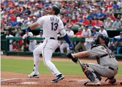  ?? Associated Press ?? ■ Texas Rangers' Joey Gallo (13) and Houston Astros catcher Brian McCann, right, watch a fly out to left by Gallo in the first inning of an opening day baseball game Thursday in Arlington, Texas.