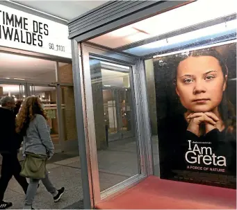  ?? GETTY IMAGES ?? Moviegoers arrive at Kino Internatio­nal movie theatre as a poster advertises the film IAm Greta, about the Swedish environmen­tal activist Greta Thunberg, on November 1, 2020 in Berlin.