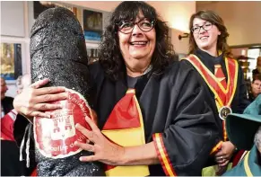  ?? — Photos: AFP ?? A member of the brotherhoo­d of the ‘True Andouille of Vire’ presents an oversized plastic sausage at the 38th annual general meeting of the Brotherhoo­d of Tripiere Fertoise.