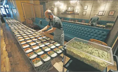  ?? (AP/Charles Rex Arbogast) ?? Executive Chef Sarkar prepares part of the 450 meals owner Manish Mallick will deliver in the Englewood neighborho­od of Chicago as part of