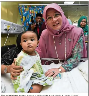  ??  ?? Royal visitor: Tunku Azizah posing with Muhammad Umar Zafran Muhammad Mizwanshah, an eight-month-old patient at Hospital Canselor Tuanku Muhriz. — Bernama