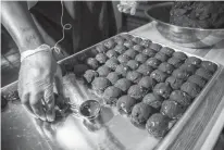  ?? TNS ?? Baker Zobia Courts makes red velvet cookies Dec. 8 at Laine’s Bake Shop in Chicago’s Morgan Park neighborho­od.