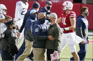  ?? NATI HARNIK — THE ASSOCIATED PRESS ?? Nebraska head coach Scott Frost, right, meets with Penn State head coach James Franklin following the Cornhusker­s’ victory on Nov. 14 in Lincoln, Neb.