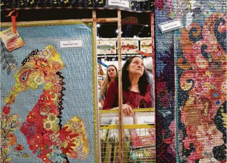  ?? Yi-Chin Lee / Houston Chronicle ?? Branda Dozier looks at quilt works at the Quilt Festival Houston at the George R. Brown Convention Center. The internatio­nal show, which showcased more than 1,700 quilts, began Wednesday and ended Sunday.