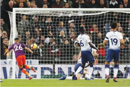  ?? Associated Press ?? Manchester City’s Riyad Mahrez (left) scores against Tottenham Hotspur during their English Premier League match at the Wembley Stadium in London on Monday.