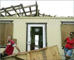  ?? CARLOS GIUSTI — THE ASSOCIATED PRESS ?? Julio Morales and Miriam Pagan stand on the front of their damaged home, in El Negro community a day after the impact of Hurricane Maria, Puerto Rico, Thursday. As of Thursday evening, Maria was moving off the northern coast of the Dominican Republic...