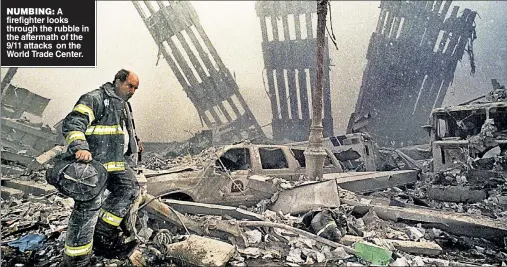  ??  ?? NUMBING: A firefighte­r looks through the rubble in the aftermath of the 9/11 attacks on the World Trade Center.