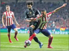  ??  ?? Lodi, del Atlético, defiende un balón ante Salah, del Liverpool.