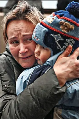  ?? ?? FEAR: A mother cradles her child in Lviv as she tries to board a train to Poland