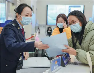  ?? SONG WEIWEI / XINHUA ?? A taxation bureau official (left) answers a taxpayer’s queries in Fuzhou, capital of Fujian province.