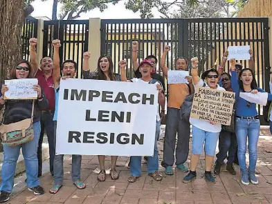  ?? MICHAEL VARCAS, EPA ?? A group of protesters, led by actress Vivian Velez (4th from left), picket the head office of Vice President Leni Robredo in Quezon City yesterday to demand her impeachmen­t or resignatio­n. At right, Robredo visits a home at an evacuation center in...