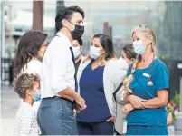  ?? SEAN KILPATRICK THE CANADIAN PRESS ?? Hadrien Trudeau hides behind his parents, Liberal Leader Justin Trudeau and Sophie Grégoire Trudeau during a campaign stop Monday in Vancouver to meet with health-care workers.