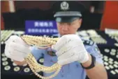  ?? ZHANG HAILONG / FOR CHINA DAILY ?? An officer shows smuggled ivory products at Huangpu Customs in Guangzhou, Guangdong province, on Monday.