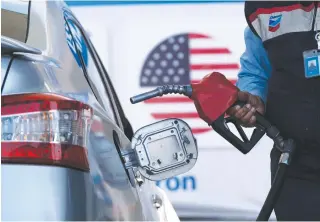  ?? AFP PHOTO ?? PRICEY
An employee fills a car’s tank at a gas station in Tijuana, Baja California state, Mexico, on Thursday, March 24, 2022 (March 25 in Manila). As the United States has registered a historical surge on fuel prices amid Russia’s war on Ukraine, gas stations in Tijuana look for US consumers crossing from California, where as of Thursday, the average price for regular gas was $5.88 per gallon and $6.31 for diesel, according to the American Automobile Associatio­n.