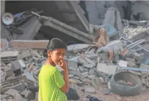  ?? — afp ?? Suffering children: a girl standing amid the rubble of a building destroyed in overnight israeli bombardmen­t in rafah.