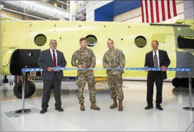  ?? SUBMITTED PHOTO ?? With a Chinook in the background, officials snip the ribbon in a ceremony at Boeing’s Ridley plant Wednesday to mark the opening of the production line for the new Chinook Block II. From left are Randy Illum, director of Chinook operations; Col. Scott...
