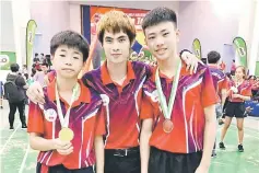  ??  ?? Brandon Tan (left) and Cody Ting share their glory with coach Yu Min Tao (centre).