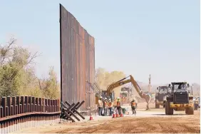  ?? MATT YORK/ASSOCIATED PRESS ?? Government contractor­s erect a section of Pentagon-funded border wall along the Colorado River in Yuma, Arizona, in September. Sixty-five acres of land were transferre­d to the Army on Tuesday.
