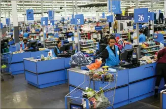  ?? EDUARDO MUNOZ ALVAREZ — THE ASSOCIATED PRESS ?? Cashiers process purchases at a Walmart Supercente­r in North Bergen, N.J., on Feb. 9.