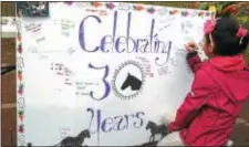  ??  ?? Above, a student signs the board commemorat­ing a 30-year collaborat­ion between Howell Farm and Isles.