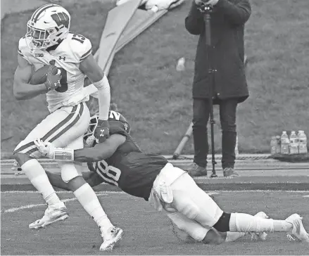  ?? MARK HOFFMAN, MILWAUKEE JOURNAL SENTINEL ?? Wisconsin wide receiver Chimere Dike sheds a tackle by Northweste­rn defensive back Cameron Ruiz during his 49-yard touchdown catch in the first quarter Saturday.