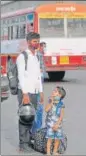  ?? HT ?? A migrant worker with his two children waiting for a bus in Lucknow on Tuesday.