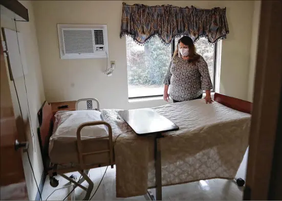  ?? CURTIS COMPTON/CURTIS.COMPTON@AJC.COM ?? Nursing administra­tor Jennifer Vasil looks over a bed in an empty room on the hallway at Westbury Medical Care and Rehab where residents with COVID-19 have since died. The memories of the worst trauma of the ongoing pandemic weigh heavily on front-line health care workers like Vasil.