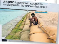  ?? ?? AT RISK A man sits on a protective sandbag wall in the Maldives last month