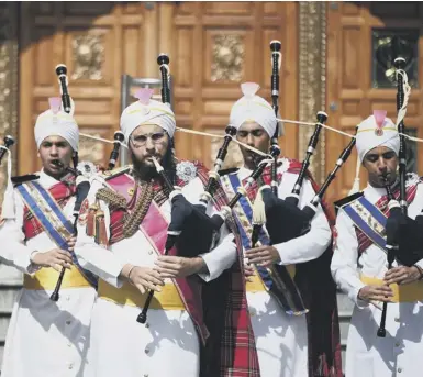  ??  ?? 0 Malaysian Sikh Band the Sri Dasmesh Pipe Band tune up before performing