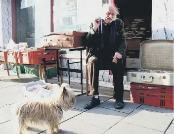  ??  ?? Eric Kitson and Skippy pictured outside his shop in Victoria Road