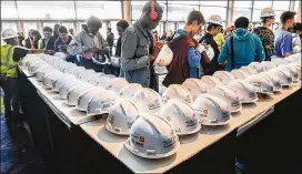  ?? JOHN AMIS / FOR ATLANTA JOURNAL-CONSTITUTI­ON ?? Ty Paddio (in red headphones) of Crim High in Atlanta adjusts his hard hat while waiting to enter and receive his safety gear at the SkillsUSA State Championsh­ip in March at the Georgia Internatio­nal Convention Center.