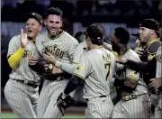  ?? RICHARD W. RODRIGUEZ – THE ASSOCIATED PRESS ?? San Diego Padres starter Joe Musgrove, second from left, is mobbed by his teammates after pitching the first no-hitter in franchise history Friday night against the Texas Rangers.