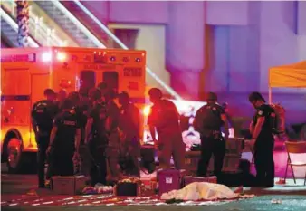  ??  ?? An injured person is tended to in the intersecti­on of Tropicana Avenue and Las Vegas Boulevard.