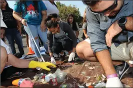  ?? BEA AHBECK/NEWS-SENTINEL FILE PHOTOGRAPH ?? Lodi High’s Angela Bravo, 17, and teacher Chris Galindo sort collected trash during the Lodi Lake Park and Mokelumne River Coastal Cleanup Day at Lodi Lake on Sept. 16, 2017.