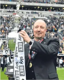  ??  ?? ■ Newcastle manager Rafael Benitez celebrates with the Championsh­ip trophy.