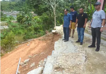  ??  ?? Jamit (front) inspects the slope where the retention wall is to be erected.