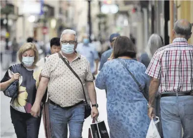  ?? GABRIEL UTIEL ?? Varias personas pasean con la obligatori­a mascarilla puesta por la céntrica calle Enmedio de Castelló.