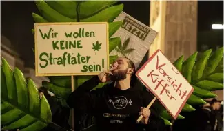  ?? ?? Man protesting marijuana legalisati­on with sign saying "We don't want to be criminals!"