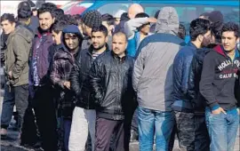  ?? Nikolay Doychinov AFP/Getty Images ?? MIGRANTS line up to buy food at Harmanli refugee camp near the border with Turkey. Camp residents were protesting a quarantine after rumors of disease.