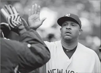  ?? DUANE BURLESON/AP PHOTO ?? Yankees starting pitcher CC Sabathia is congratula­ted in the dugout after being pulled from Saturday’s game against the Tigers in the seventh inning. He earned the victory as the Yankees won 8-4.