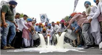  ?? — PTI ?? Members of Progressiv­e Dairy Farmers’ Associatio­n pour milk on a road protest against a cut in the prices of milk products in New Delhi in Tuesday.