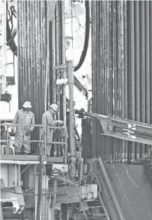  ?? San Antonio Express-News ?? Offshore oil workers are protected by more regulation­s than those onshore, like these on a Patterson-UTI rig near Whitsett.