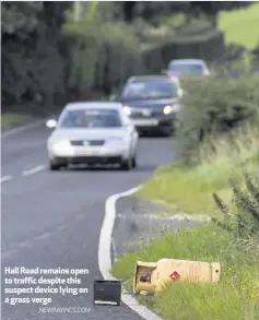  ?? NEWRAYPICS.COM ?? Hall Road remains open to traffic despite this suspect device lying on a grass verge